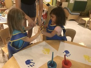 two girls painting handprints