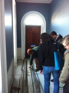 Emily Whisenant and Claire check out a wood and composite multiple layer piece of crown molding removed for restoration.